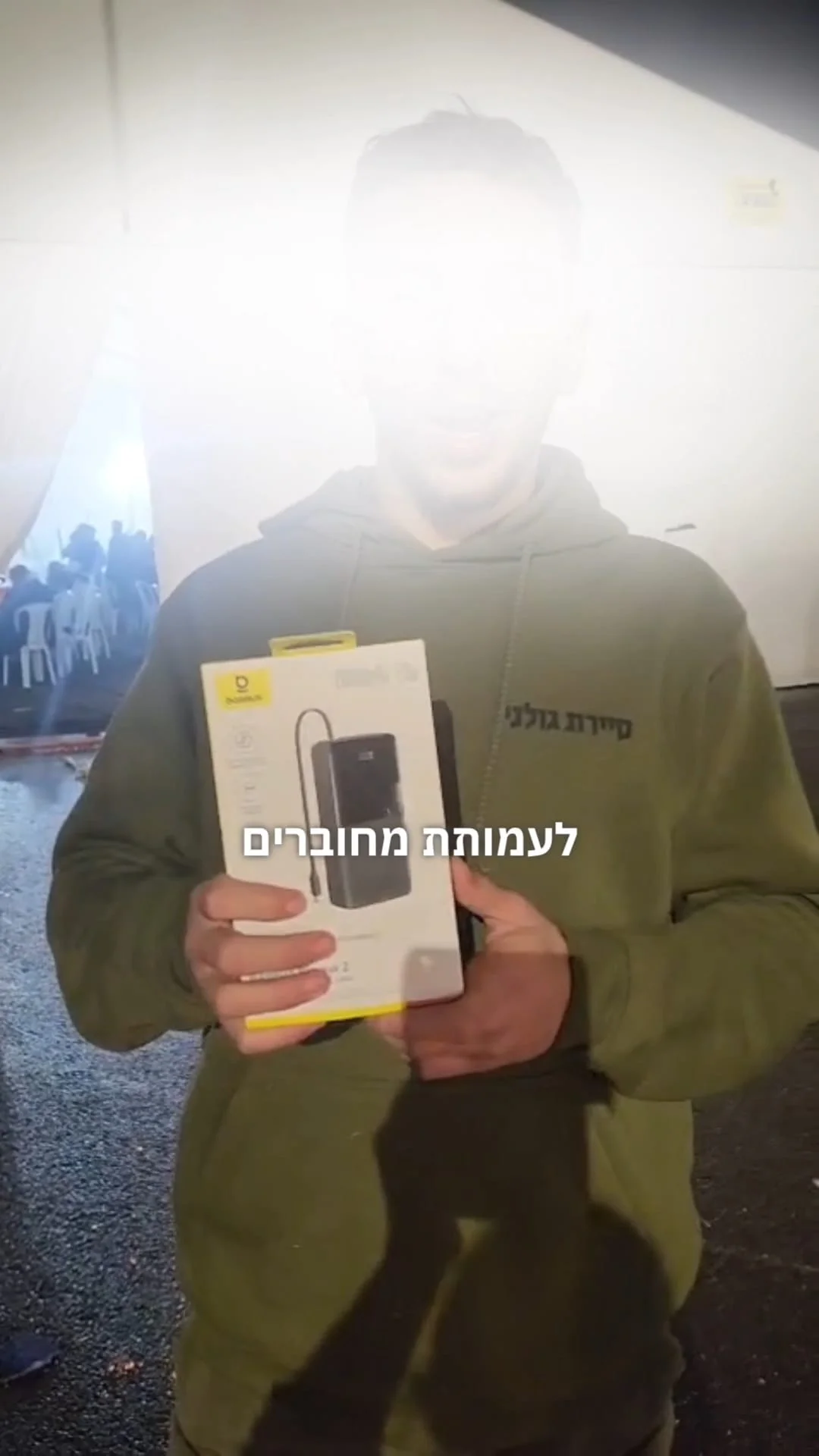 חייל מחזיק מטען נייד שקיבל בתרומה